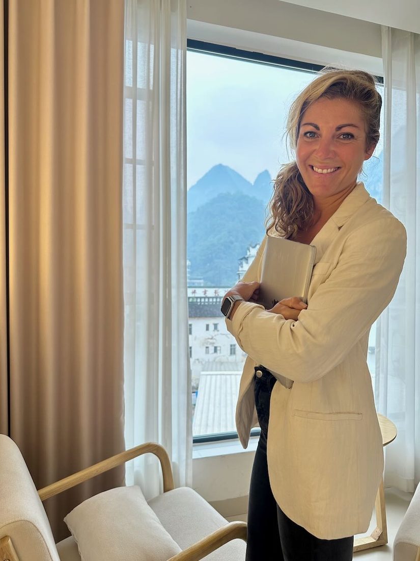 Verena with arms crossed in front of a mountain view