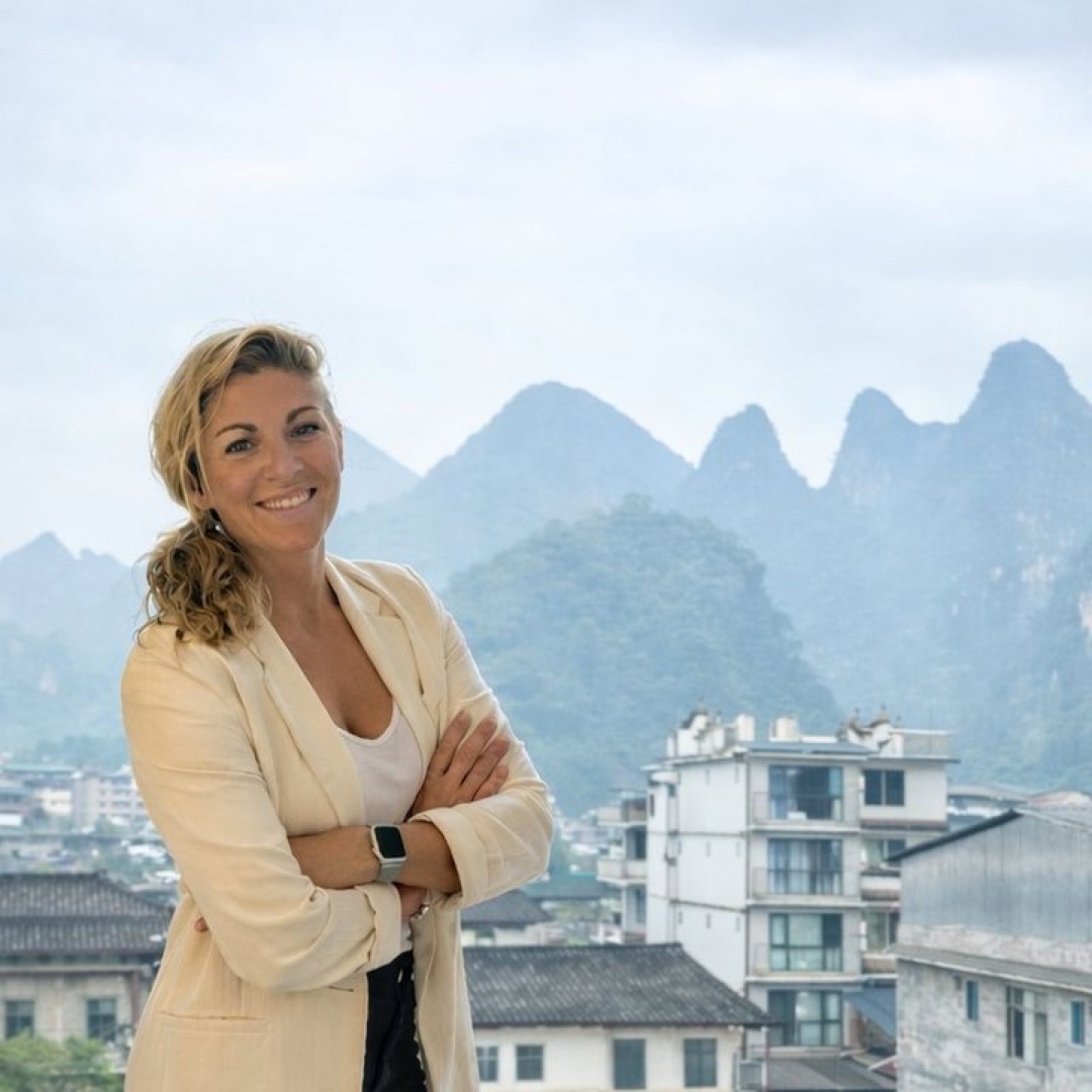 Verena diante de uma paisagem de montanhas